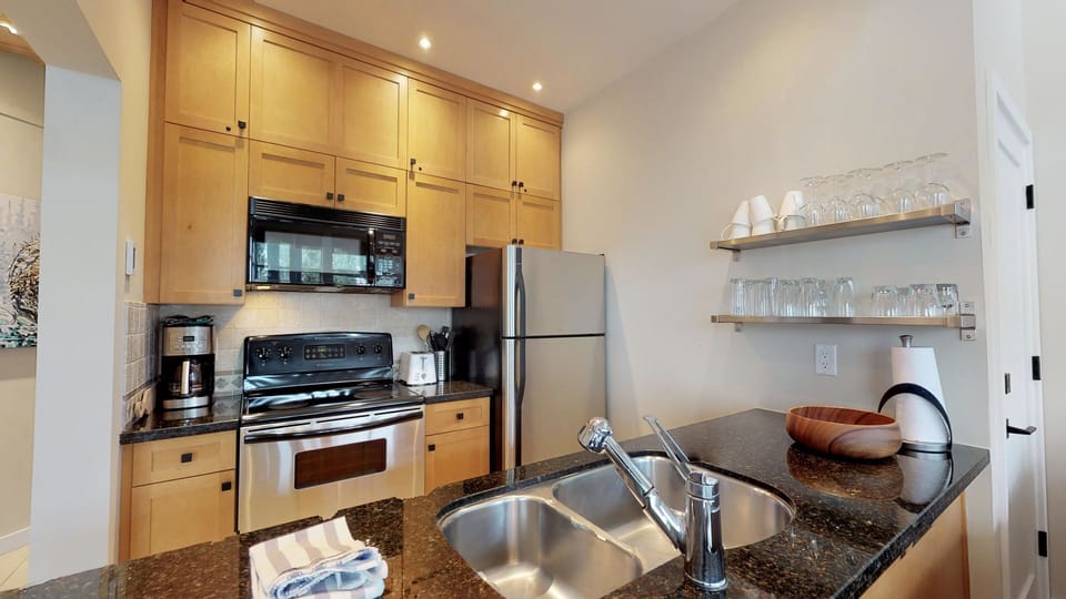The updated kitchen boasts stainless steel appliances and a modern, clean design.