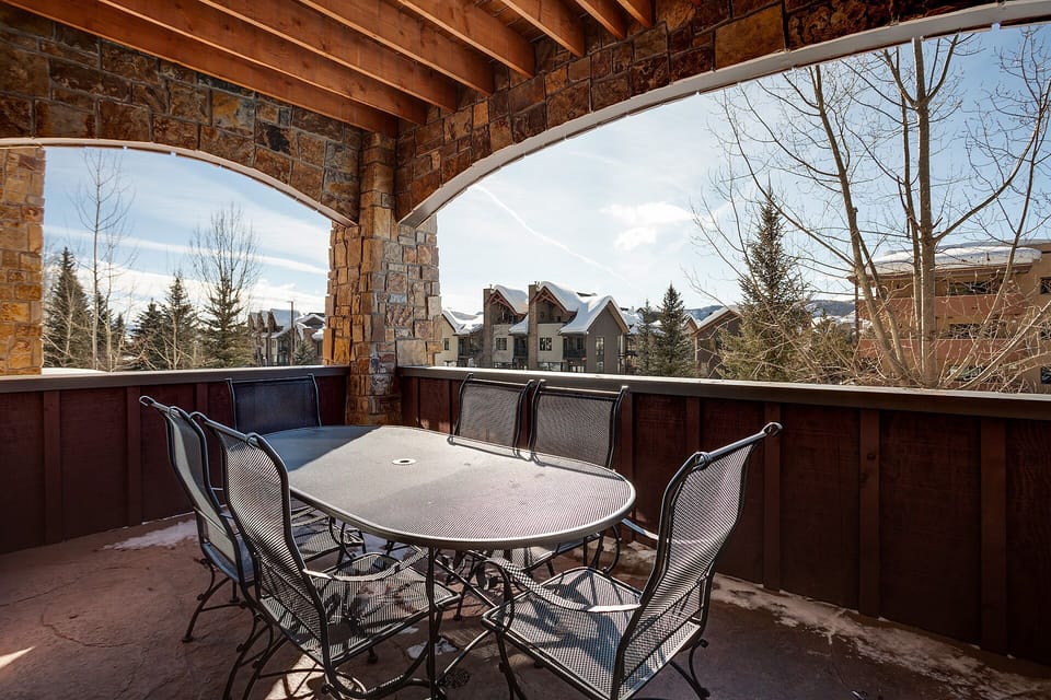Gather around your private dining table on this stone-arched balcony, where mountain views and rustic charm create the perfect outdoor retreat.