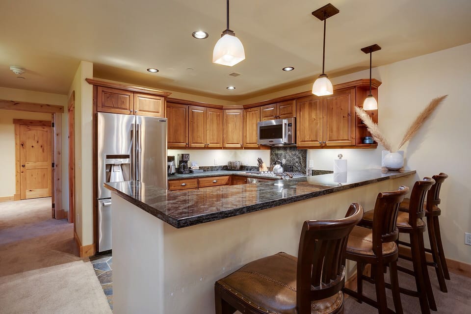 Your gourmet kitchen features granite countertops, stainless steel appliances, and breakfast bar seating perfect for morning coffee or casual dining.