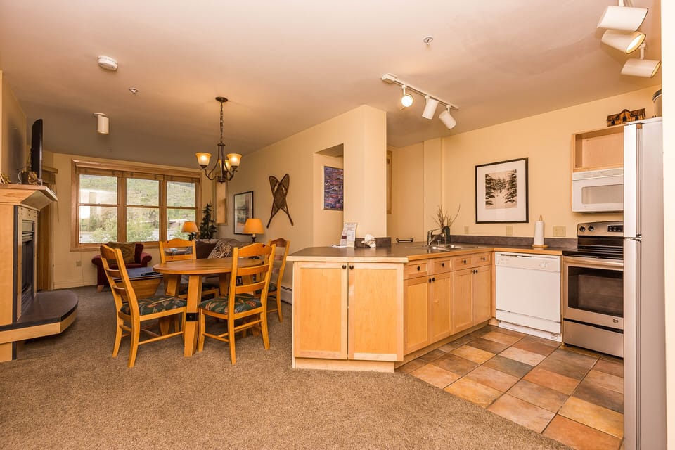 Your open-concept kitchen and dining area creates the perfect gathering space with warm wood cabinets and mountain charm.