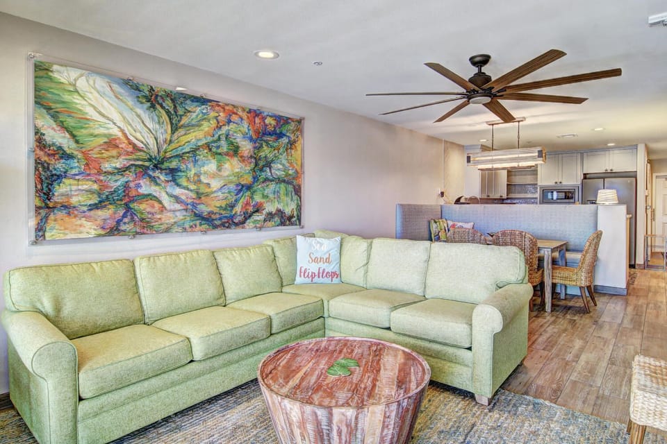 Relax on your plush sectional sofa while tropical artwork sets a vibrant mood, with your fully-equipped kitchen just steps away.