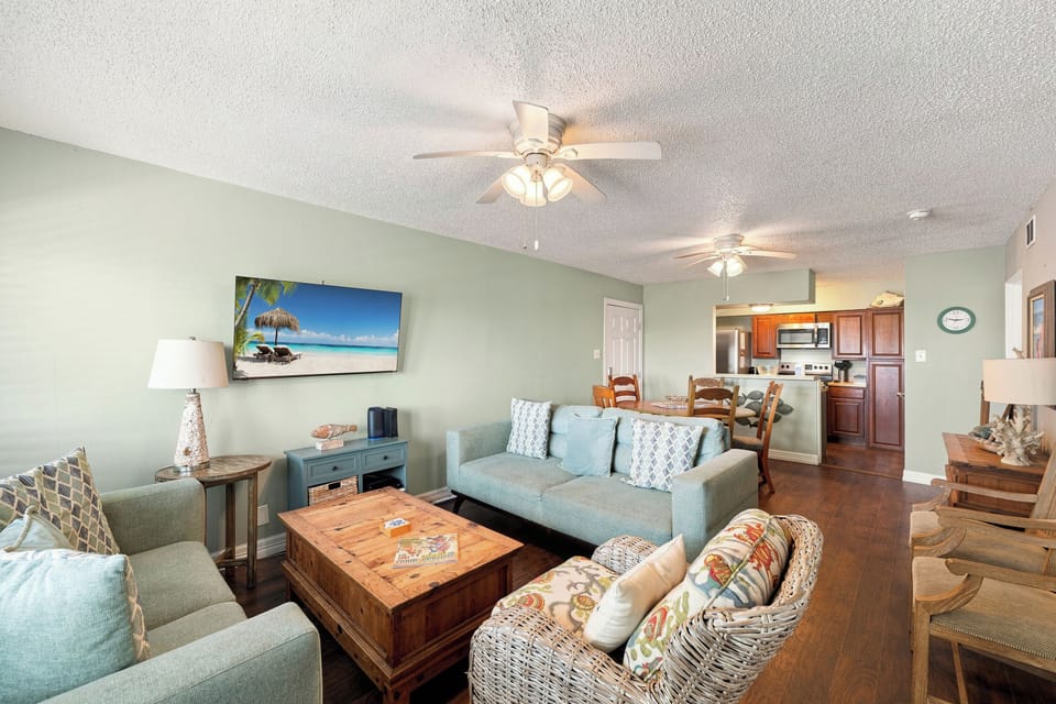 Sink into plush sofas and enjoy breezy coastal hues that wrap you in relaxation. Your open living space flows into the dining area and kitchen, making it easy to gather and unwind after a day of adventure.