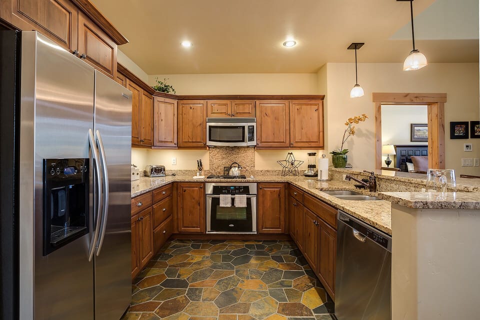 Your spacious kitchen features granite countertops, warm wood cabinets, and stainless steel appliances, perfect for preparing meals during your stay.