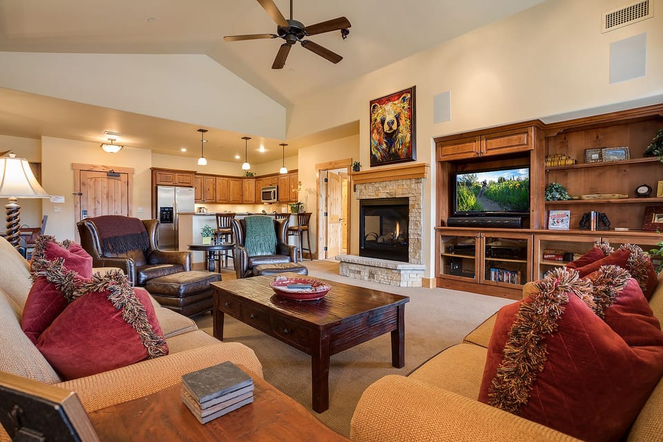 Unwind in this cozy living room with crackling fireplace, plush seating, and rich wood details creating your perfect mountain retreat atmosphere.