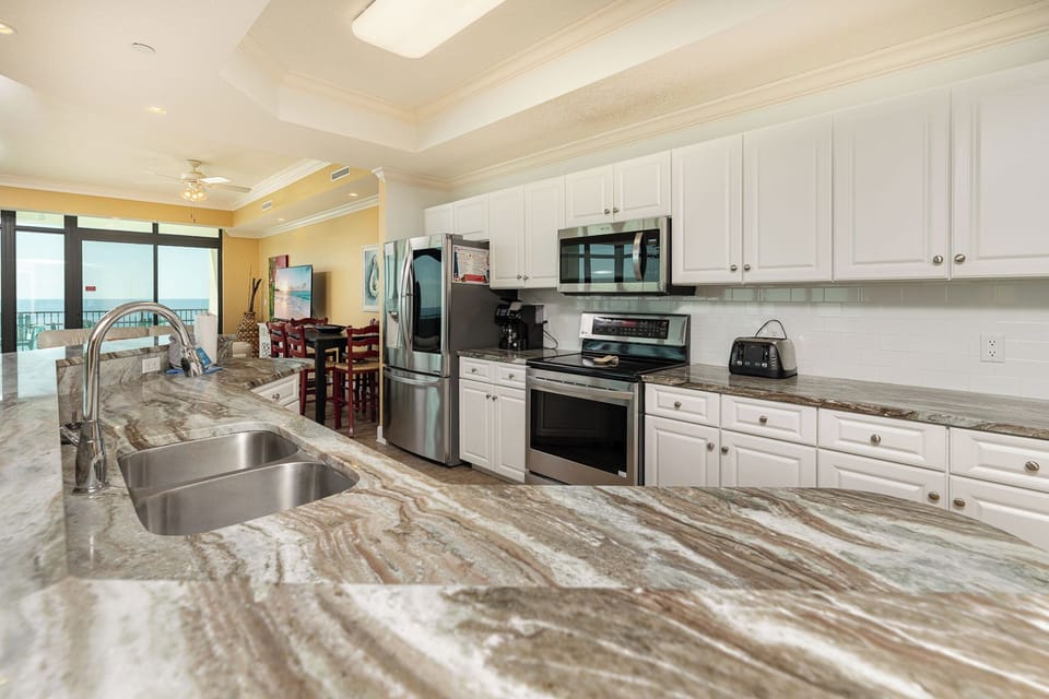Soft lighting fills the kitchen as you prepare snacks for family fun before stepping onto the beachfront balcony