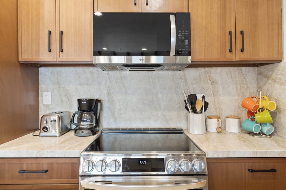 Your kitchen is fully equipped with modern appliances—coffee maker, toaster, and a sleek range oven—ready for your morning routine or a cozy meal at home.