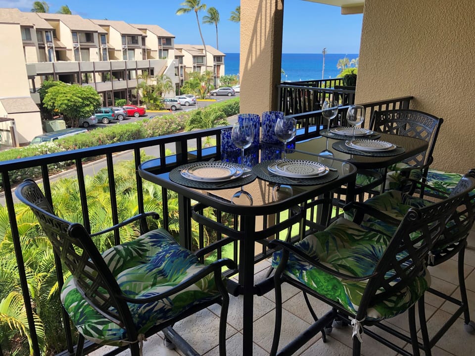 A tropical paradise awaits at your private outdoor dining spot, perfectly set for meals with ocean breezes, swaying palms, and stunning blue horizon views beyond lush gardens.