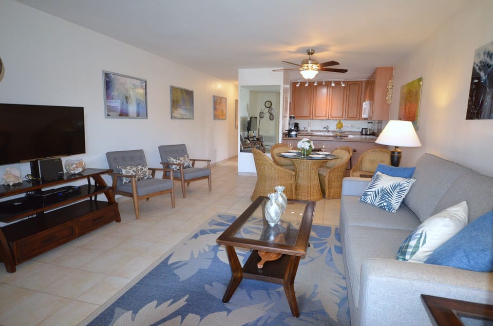 Your open-concept living space invites you to unwind with plush seating, coastal-inspired décor, and a fully equipped kitchen just steps away—perfect for leisurely mornings and relaxed evenings together.