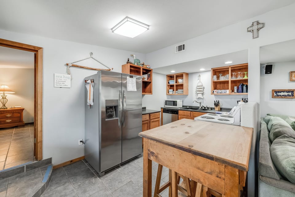 Your fully-equipped kitchen features warm wood cabinets, stainless appliances, and a rustic island perfect for meal prep and casual dining.