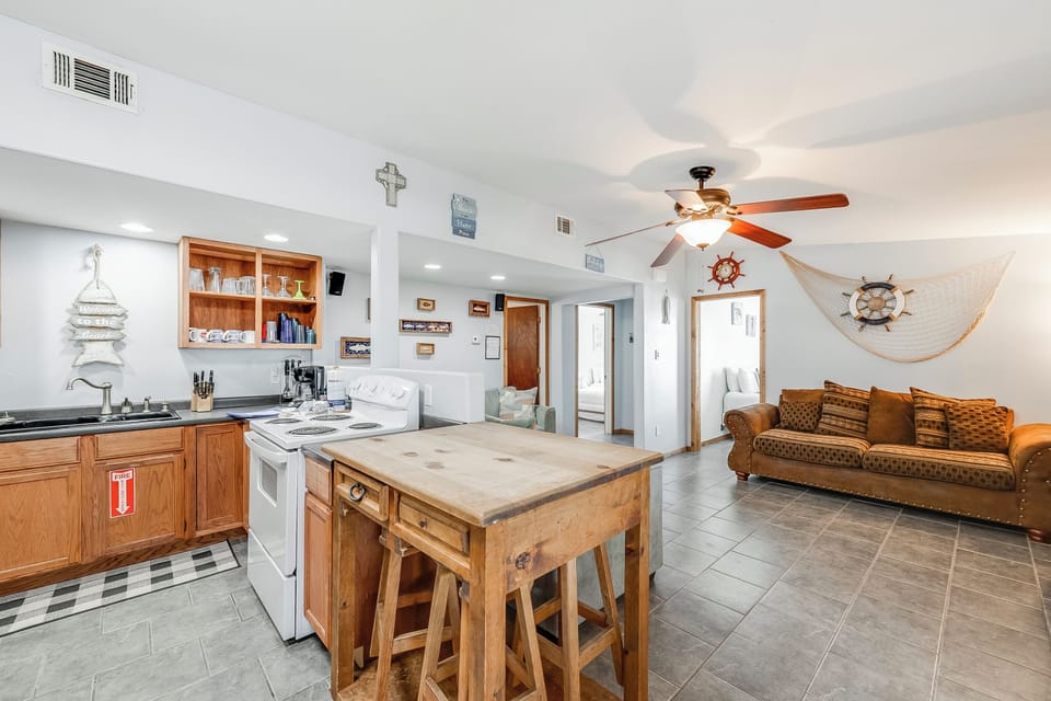 Your nautical-themed retreat features an open kitchen with island seating, perfect for preparing coastal feasts while mingling with loved ones.