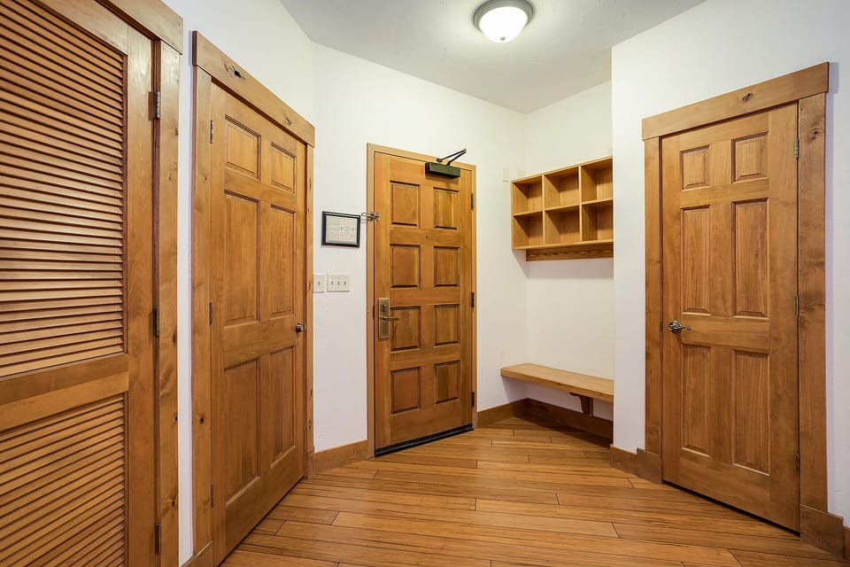 Step into your private entryway where warm wood details and built-in storage create the perfect spot to settle in.