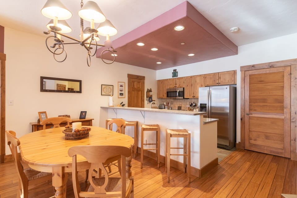 Your open-concept kitchen and dining area features warm wood floors, granite counters, and cozy breakfast bar seating for memorable meals.