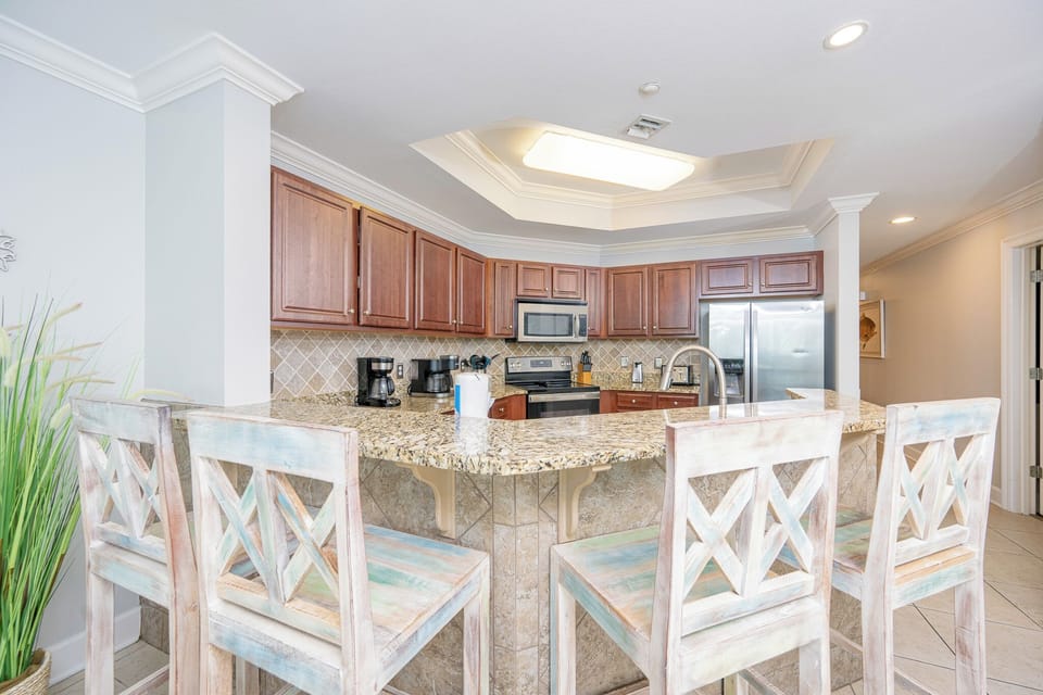 Inviting kitchen with granite countertops, stainless appliances, and charming bar seating for a cozy dining experience