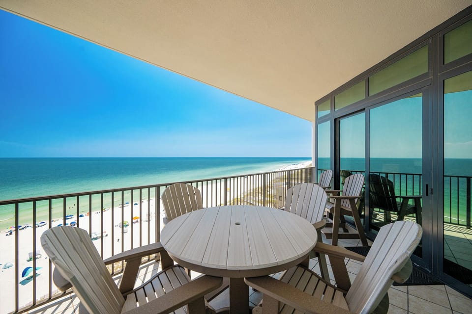 Relax on the spacious balcony with impressive views of the pristine beach and vibrant blue waters