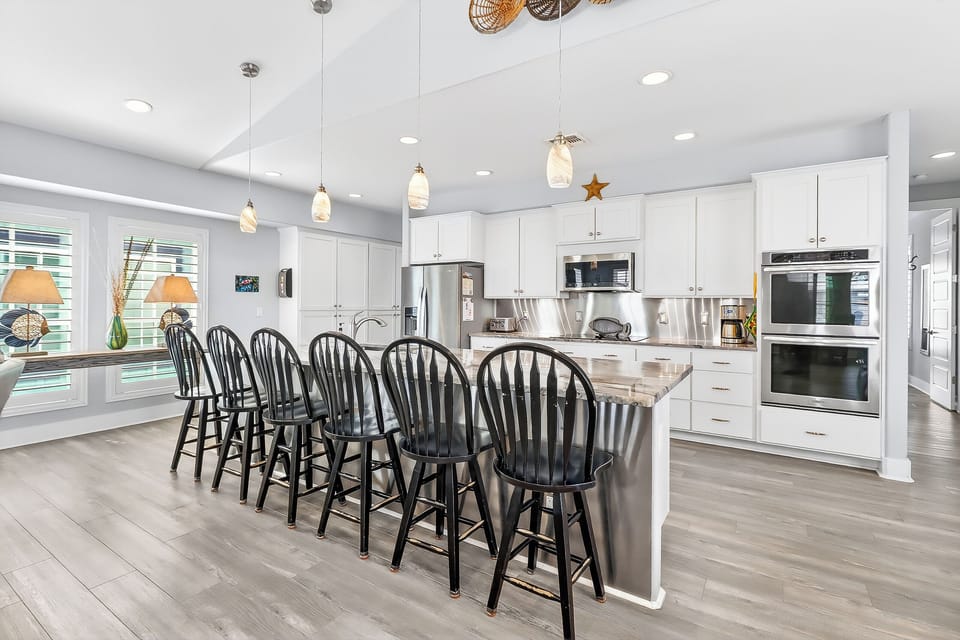 Your spacious kitchen awaits with gleaming countertops, modern appliances, and a breakfast bar where you'll gather for morning coffee.