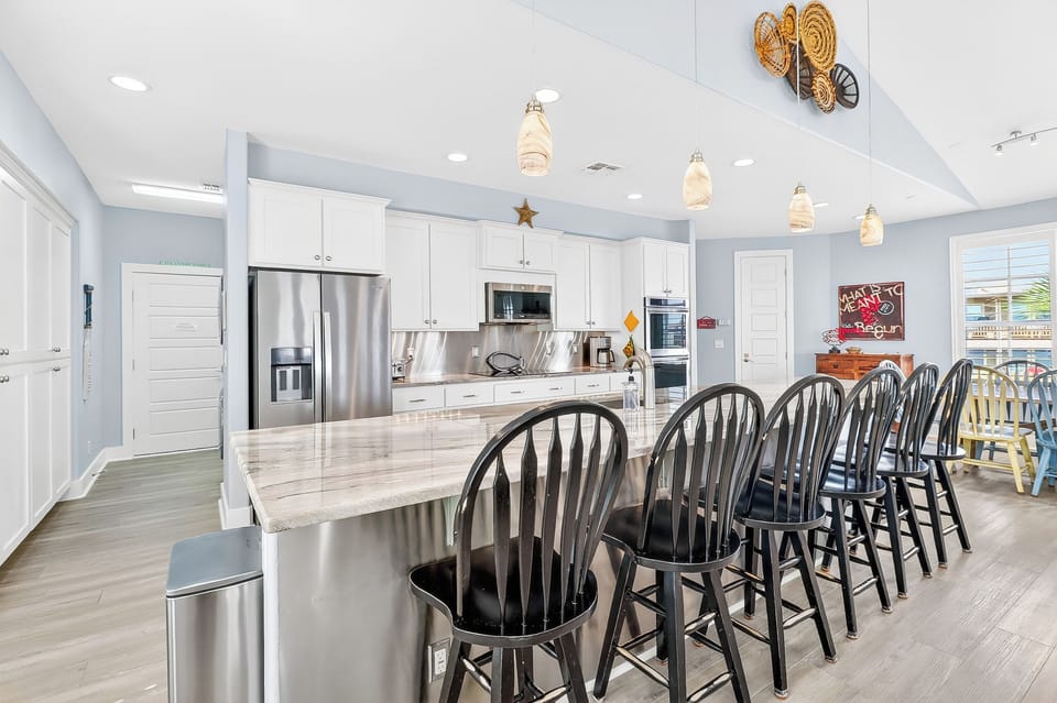 Your dream kitchen awaits with marble countertops, stainless steel appliances, and a breakfast bar for eight—perfect for morning coffee or evening gatherings.