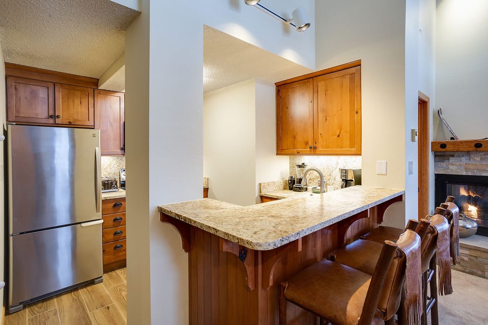 Your gourmet kitchen features granite countertops, stainless steel appliances, and a breakfast bar where you'll savor morning coffee by the cozy fireplace.