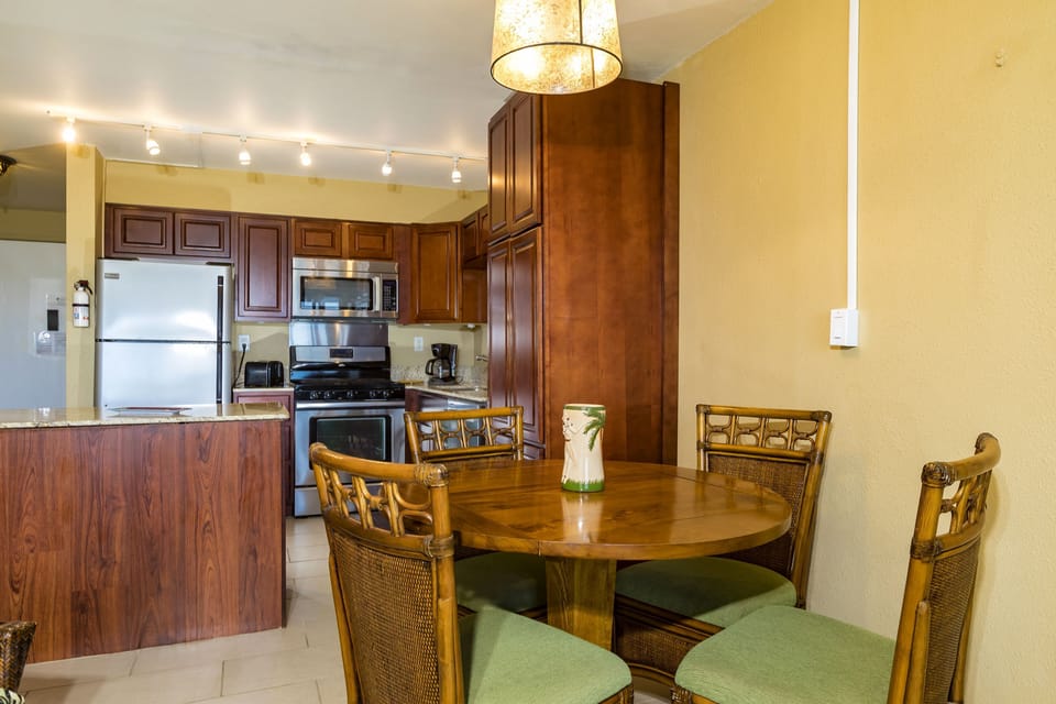 Your inviting kitchen and dining area features warm wood cabinetry, stainless steel appliances, and a cozy round table perfect for gathering over morning coffee or evening meals with loved ones.