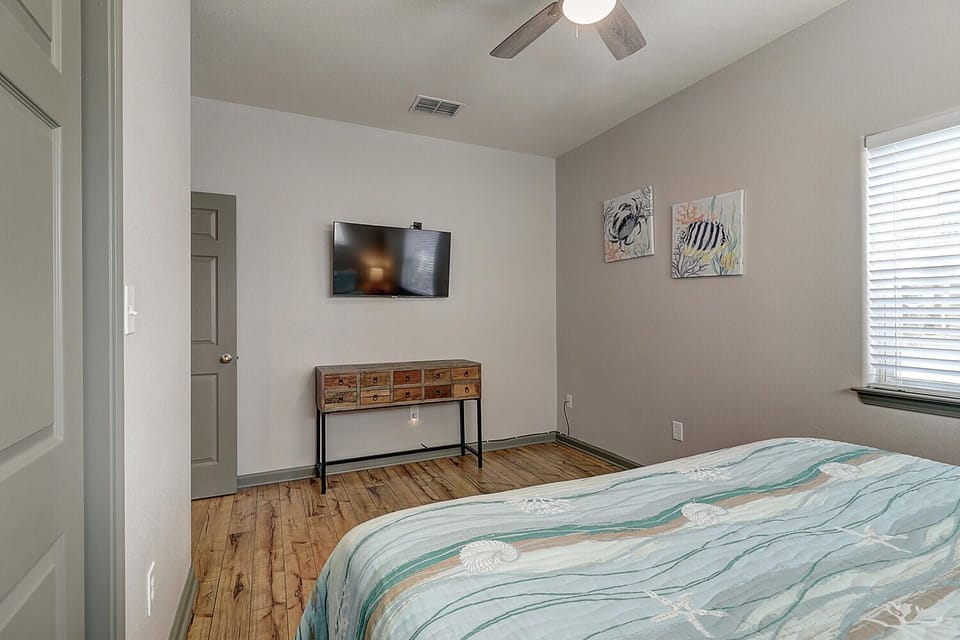 Your cozy bedroom features warm wood floors, charming nautical artwork, and a wall-mounted TV for relaxing evenings in.