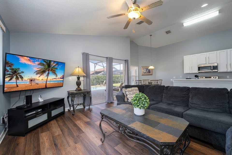 Living room showing sectional seating, TV and pool access