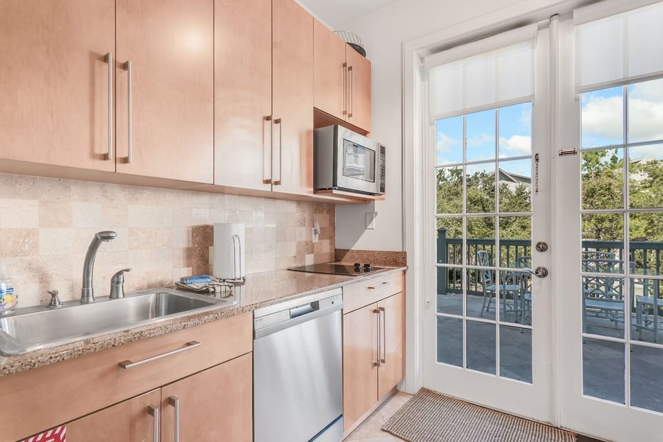 Kitchenette with sink, dishwasher, two mini fridges, Keurig and drip coffee machines, toaster oven, microwave, and two burner cooktop.