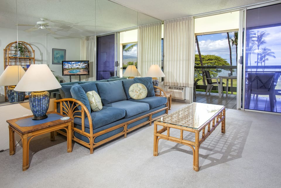 Picture yourself unwinding on this breezy lanai overlooking swaying palms and ocean views, with coastal-inspired furnishings creating your perfect island retreat.