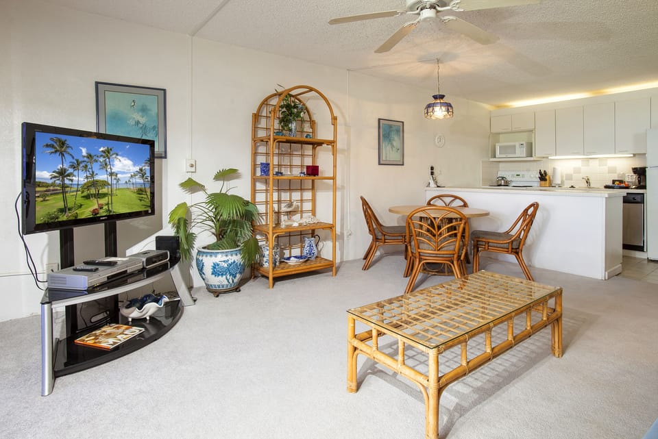 Unwind in your bright, airy living space featuring tropical rattan furnishings, a fully equipped kitchen, and coastal charm perfect for relaxing after island adventures.