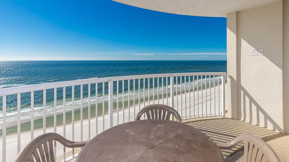 Enjoy breathtaking beachfront views from the balcony, featuring a round table and chairs for relaxing moments