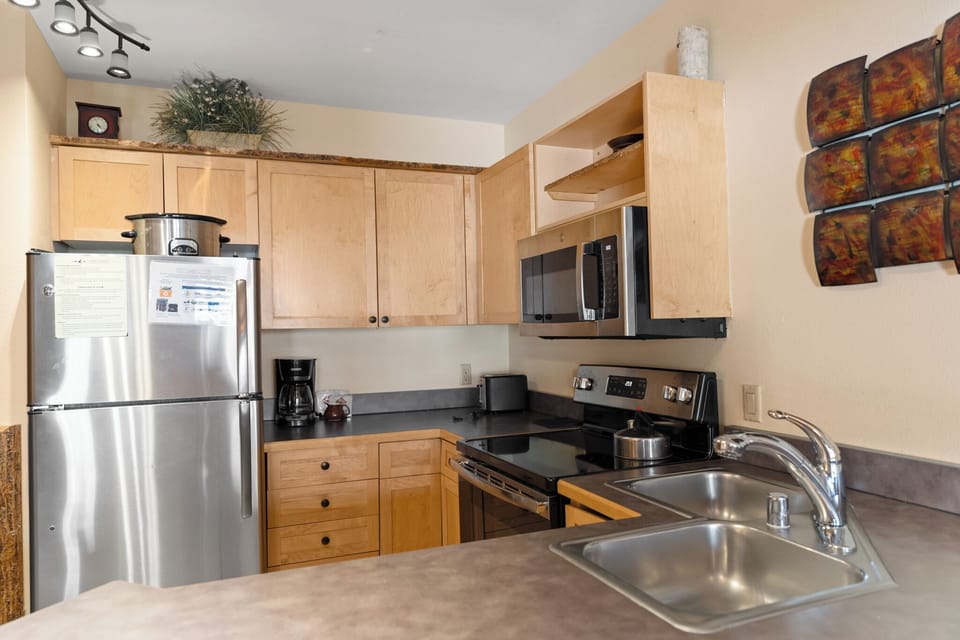 Cook your favorite meals in this fully-equipped kitchen with modern appliances and warm wood cabinetry.