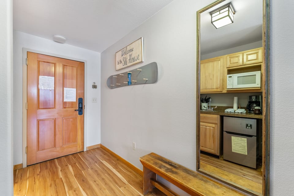 Your cozy ski lodge features a fully-equipped kitchenette with microwave, coffee maker, and mini-fridge, plus warm wooden accents throughout.