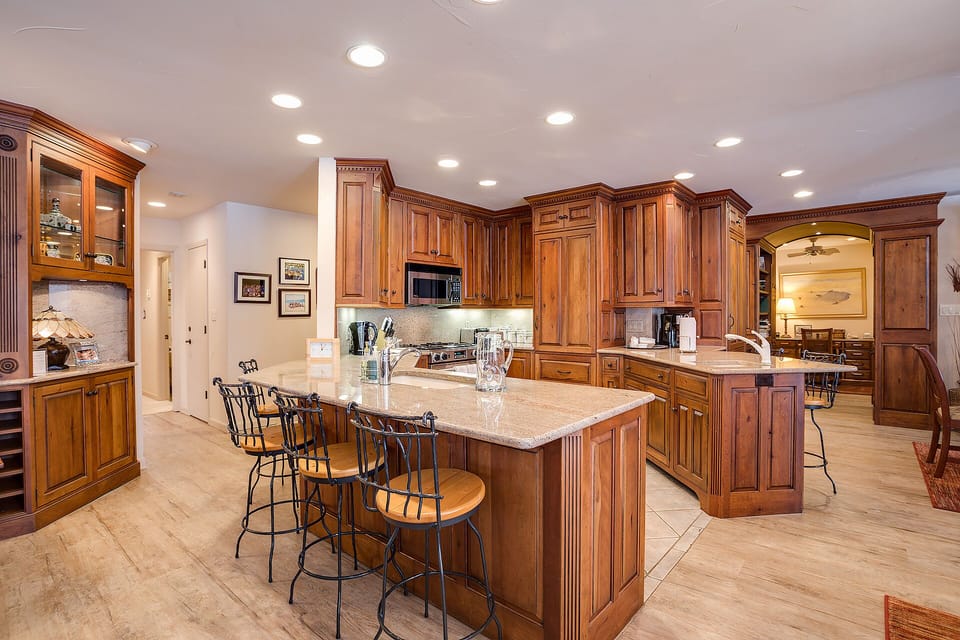 Step into your gourmet kitchen featuring rich wood cabinetry, granite countertops, and a spacious island perfect for cooking and gathering.