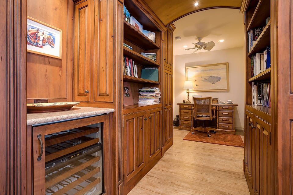Your private study features rich wood built-ins, a wine cooler, and cozy reading nooks—perfect for quiet mornings with coffee.