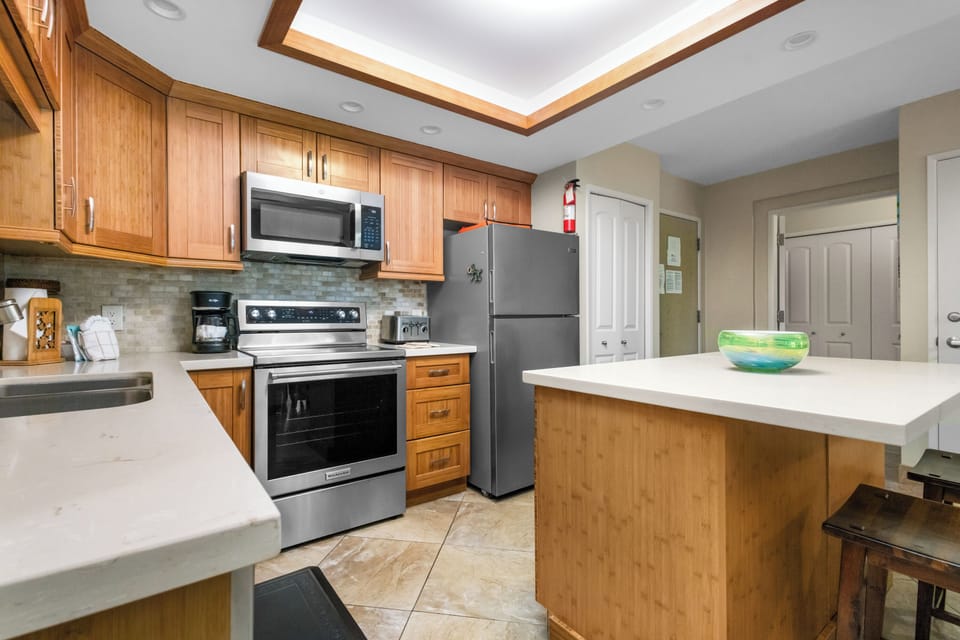 Your fully equipped kitchen features warm wood cabinetry, granite counters, and modern appliances for creating memorable meals together.