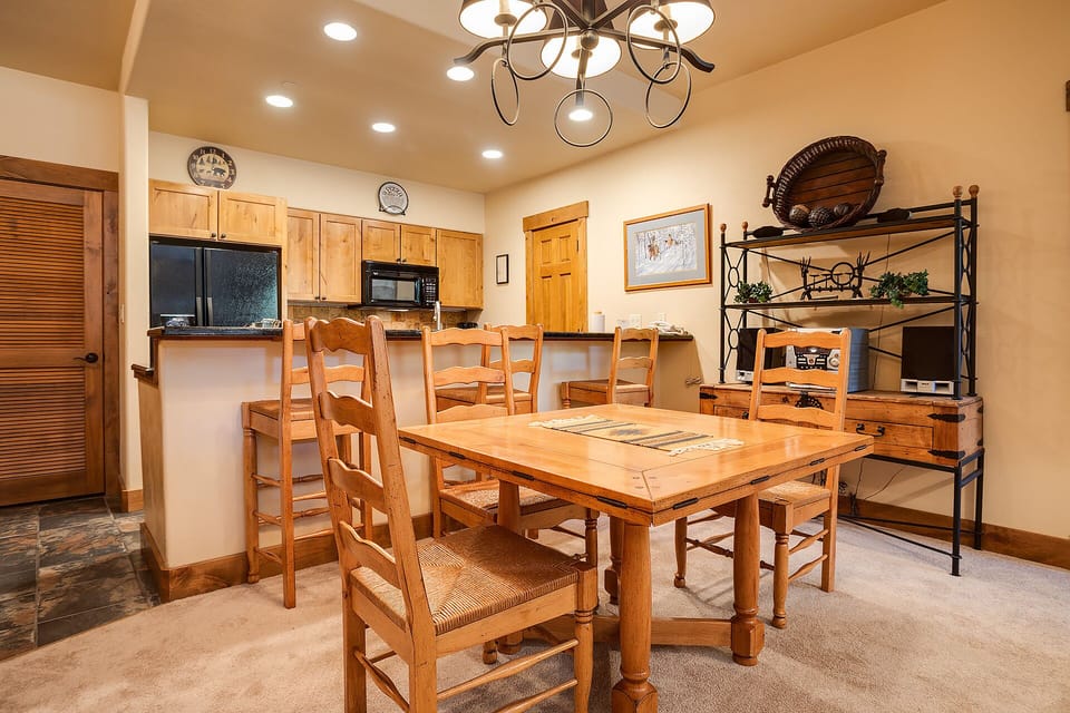 Gather around your spacious dining table for memorable meals, with a fully-equipped kitchen and warm wood accents creating the perfect home base.