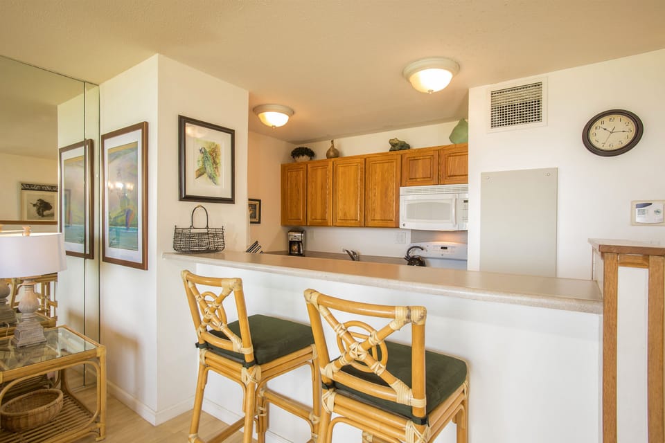 Step into your bright kitchen with warm wood cabinetry, full appliances, and a cozy breakfast bar—perfect for morning coffee or planning your day's adventures.