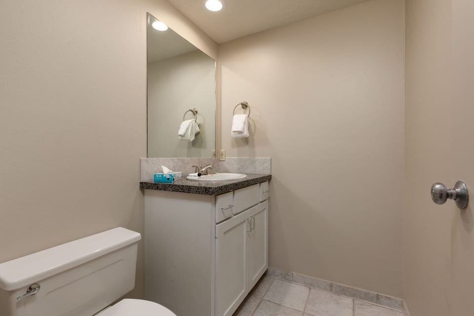 Your private bathroom features modern vanity with granite countertop, fresh towels, and bright lighting for your comfort.