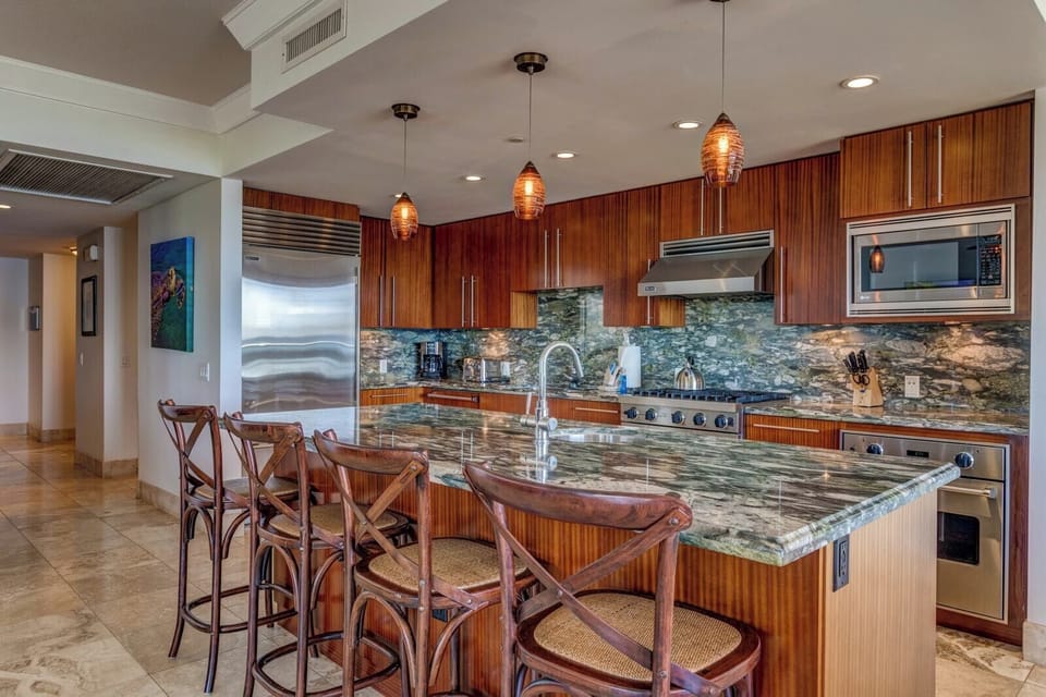 Elevated island living with a stunning open kitchen, bar seating, and a dining space made for sunset gatherings
