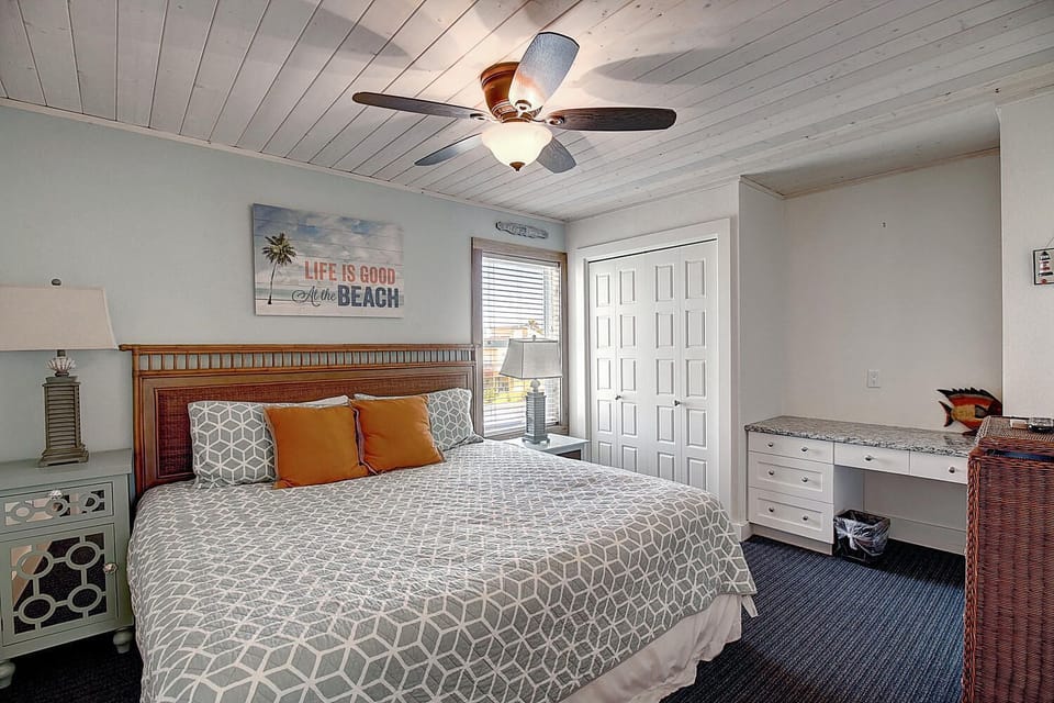 Relax in this coastal bedroom with nautical touches and a ceiling fan keeping you cool.