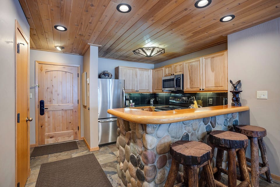 Your rustic mountain kitchen features warm wood ceilings, stone accents, and everything you need to prepare memorable meals together.