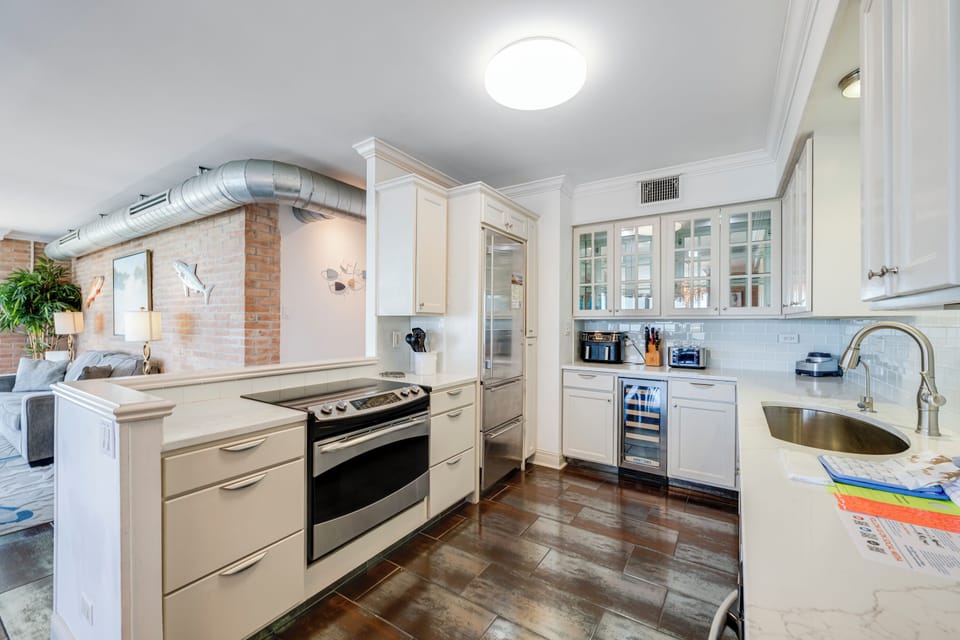 Your gourmet kitchen features gleaming white cabinetry, marble countertops, and modern appliances for memorable home-cooked meals.