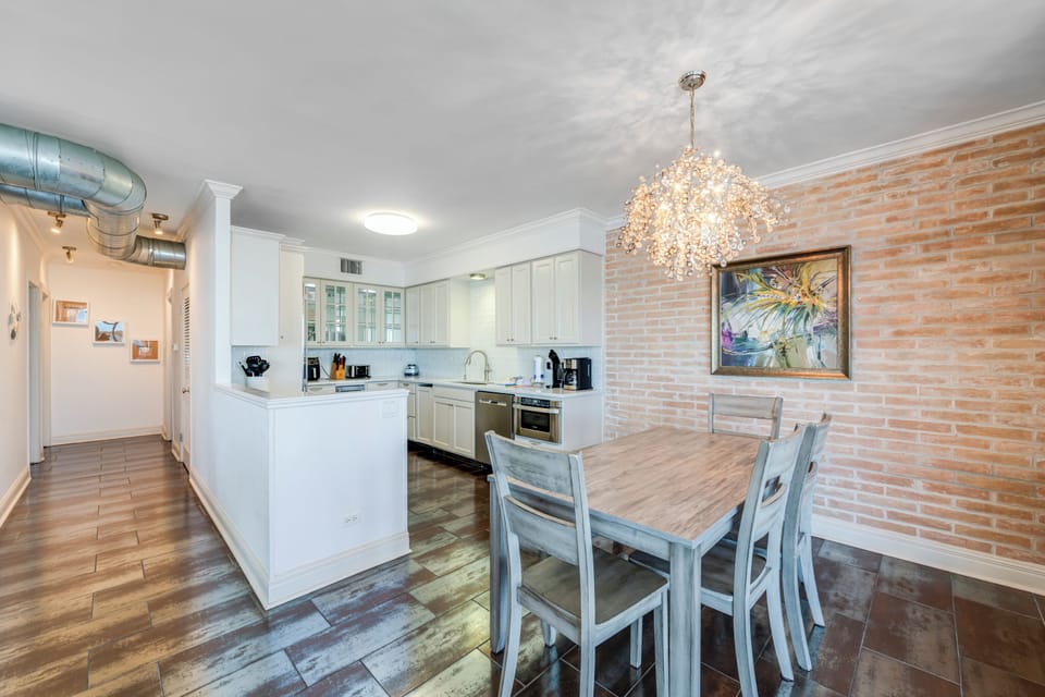 Your open-plan kitchen and dining space features modern appliances, stylish brick walls, and elegant lighting for memorable meals together.