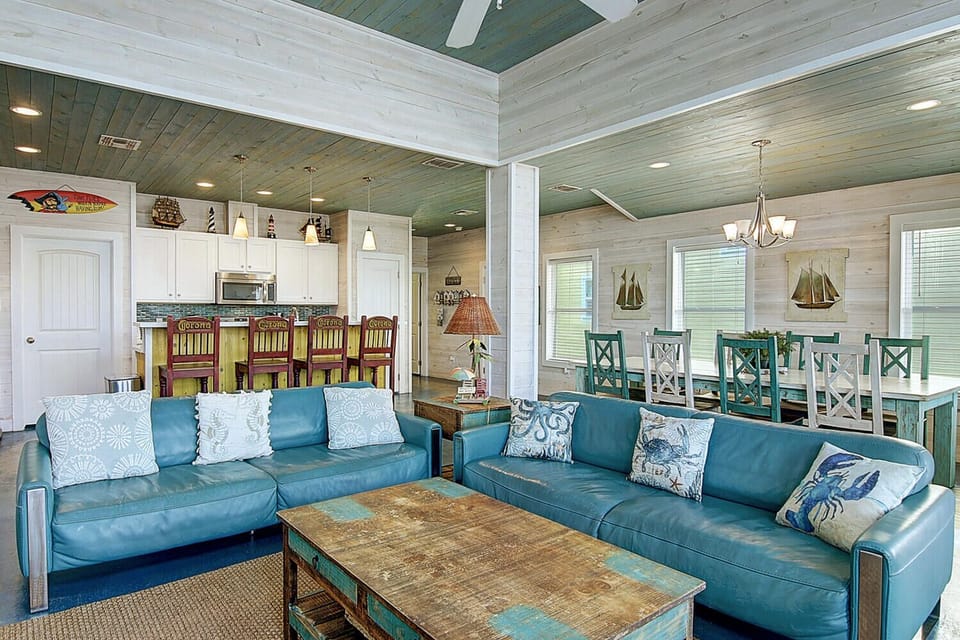 Sink into coastal comfort in your open-concept living space, where turquoise leather sofas and nautical touches create the perfect retreat.