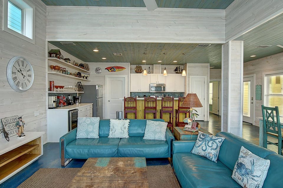 Sink into coastal comfort in your open living space, where beach-inspired blues and warm wood create the perfect retreat.