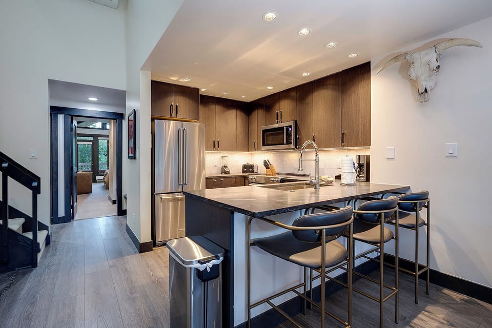 Your sleek kitchen features modern appliances and a breakfast bar where you can enjoy morning coffee while planning your day.