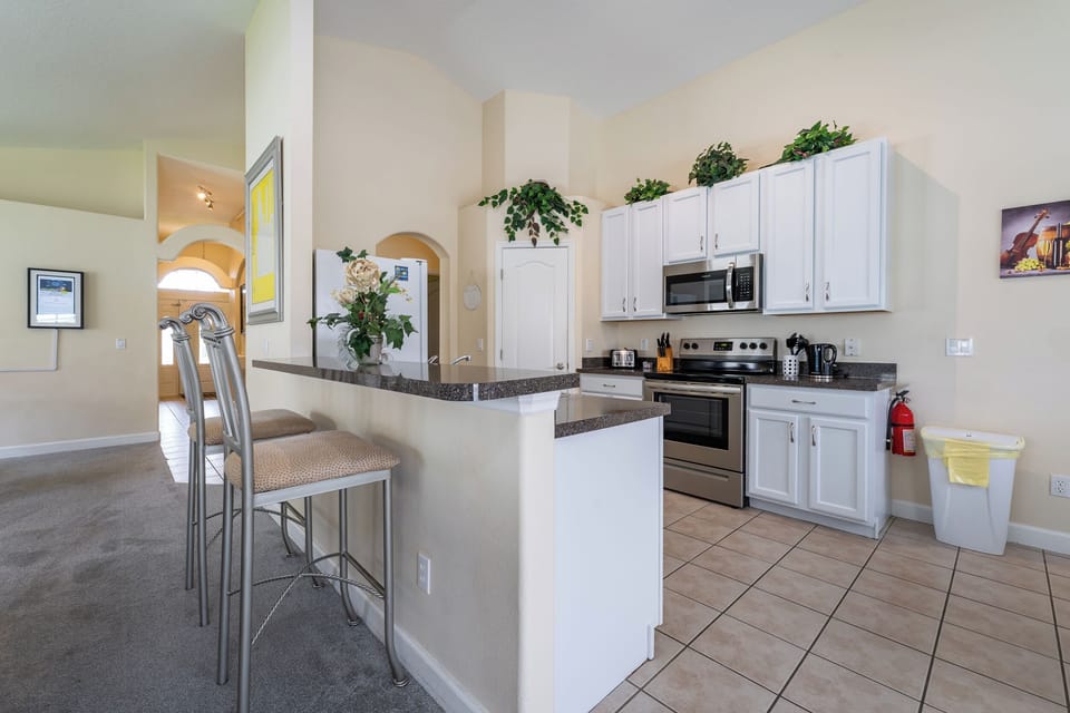 Kitchen showing galley style with white cabinetry and stainless appliances
