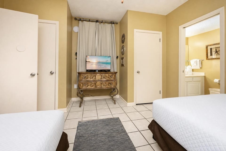 Relax in this inviting guest room featuring two double beds, a TV, and easy access to the bathroom with fresh towels
