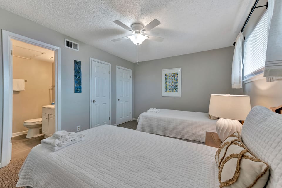 Your comfortable twin bedroom features fresh linens, soft lighting, and an ensuite bathroom for your convenience.