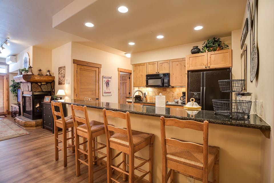 Gather around your spacious kitchen island where granite counters and warm wood create the perfect spot for morning coffee or evening conversations.