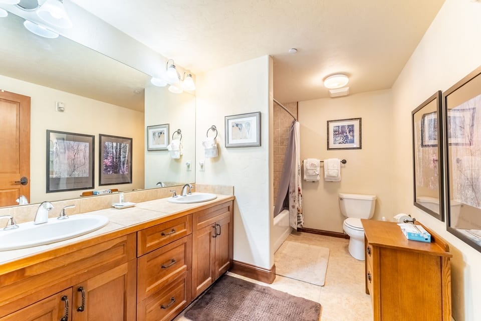 Your spacious bathroom features warm wood vanity with dual sinks, plus separate shower-tub combo for ultimate convenience and relaxation.