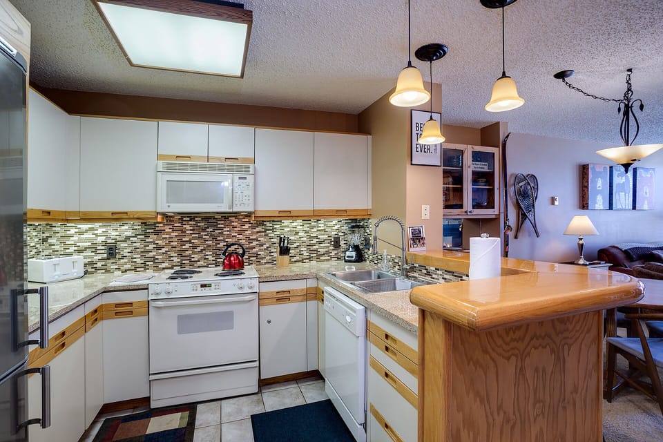 Your fully equipped kitchen awaits with granite counters, breakfast bar, and everything needed for memorable meals together.